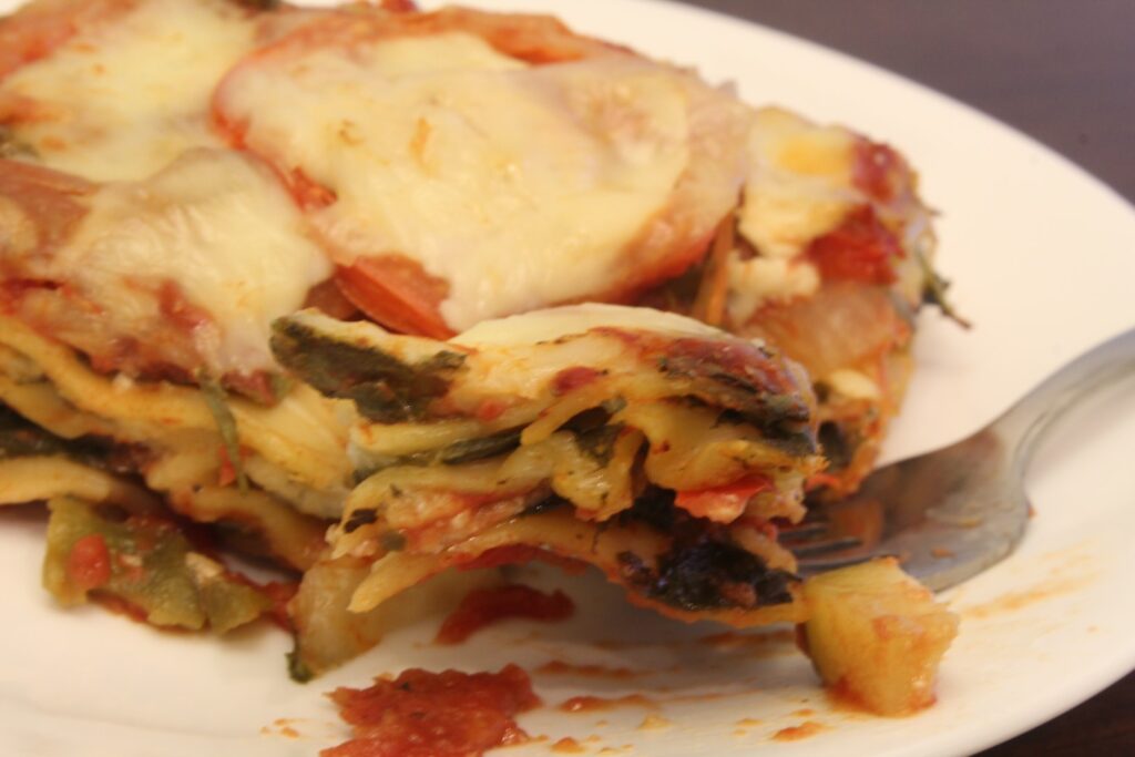 A bite of veggie lovers lasagna on a fork.