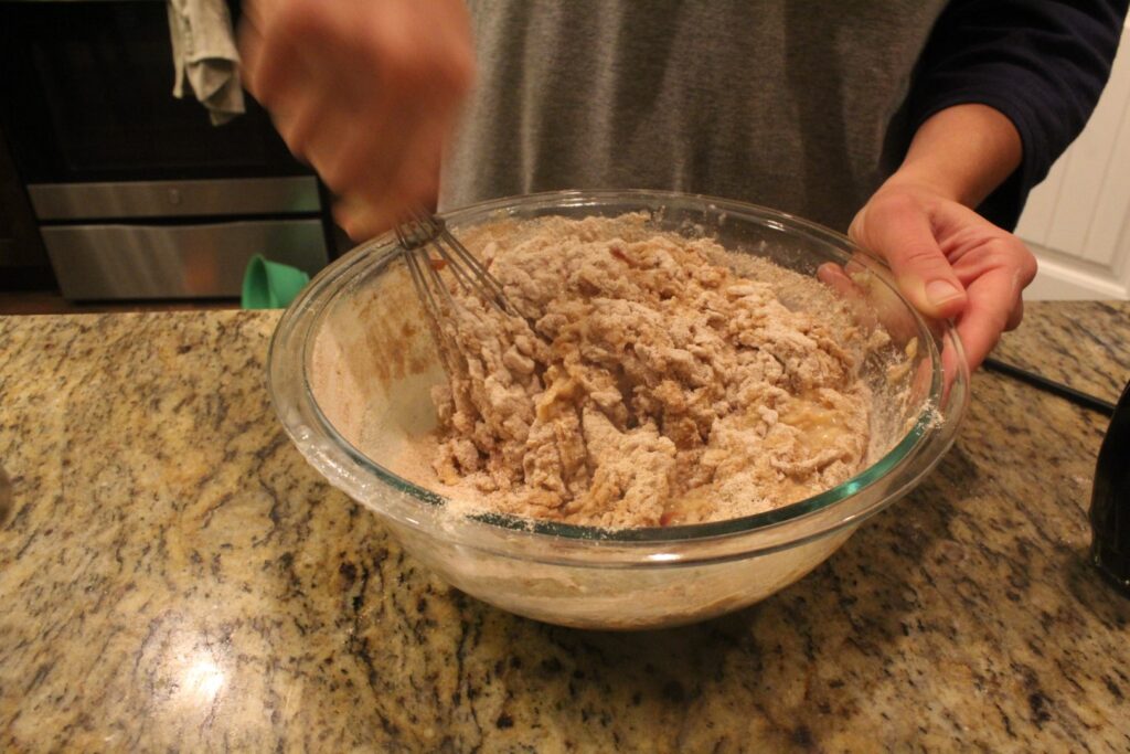 Person mixing a bowl of whole wheat muffin batter.