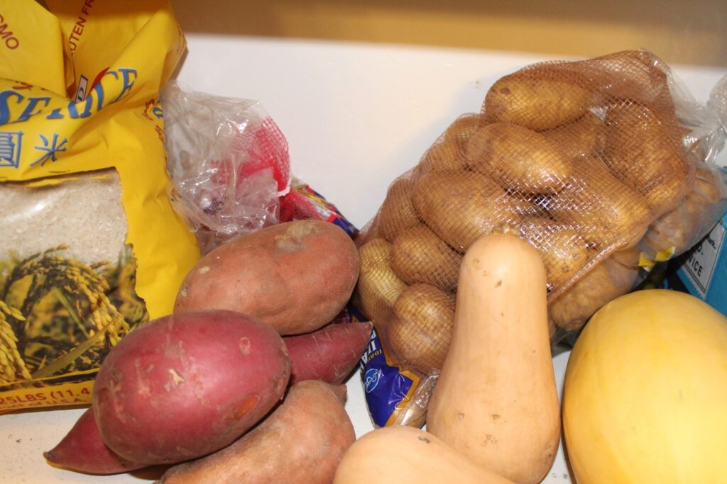 Potatoes and squash in a pantry.