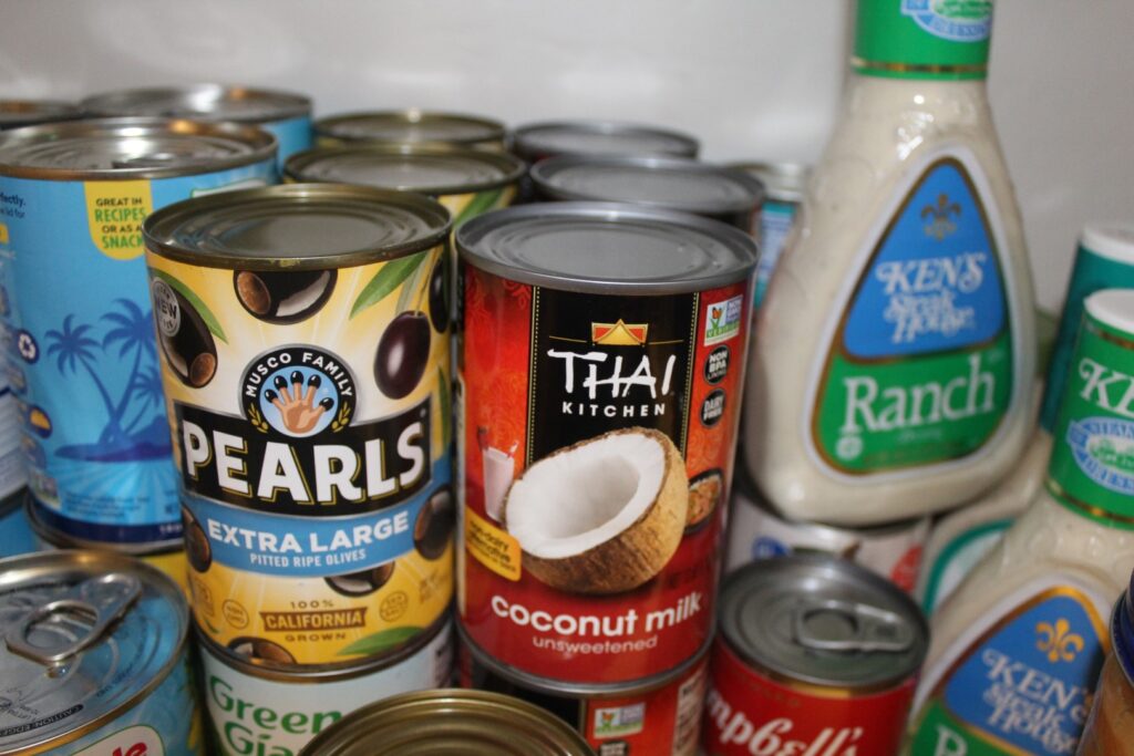 Cans and bottles of food in a pantry.