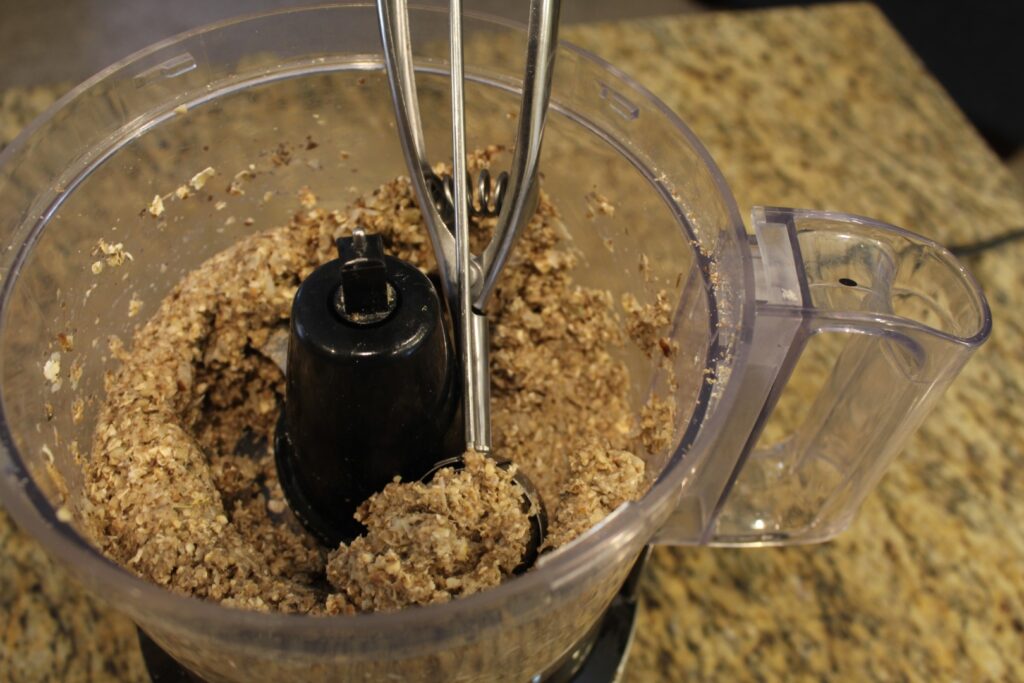 Scooping mixture out of food processor with a cookie scoop.