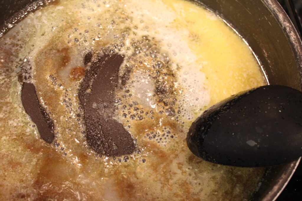 Melted butter sugar and milk being stirred in a pan.