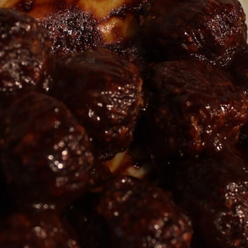 Mushroom meatballs covered in BBQ sauce.