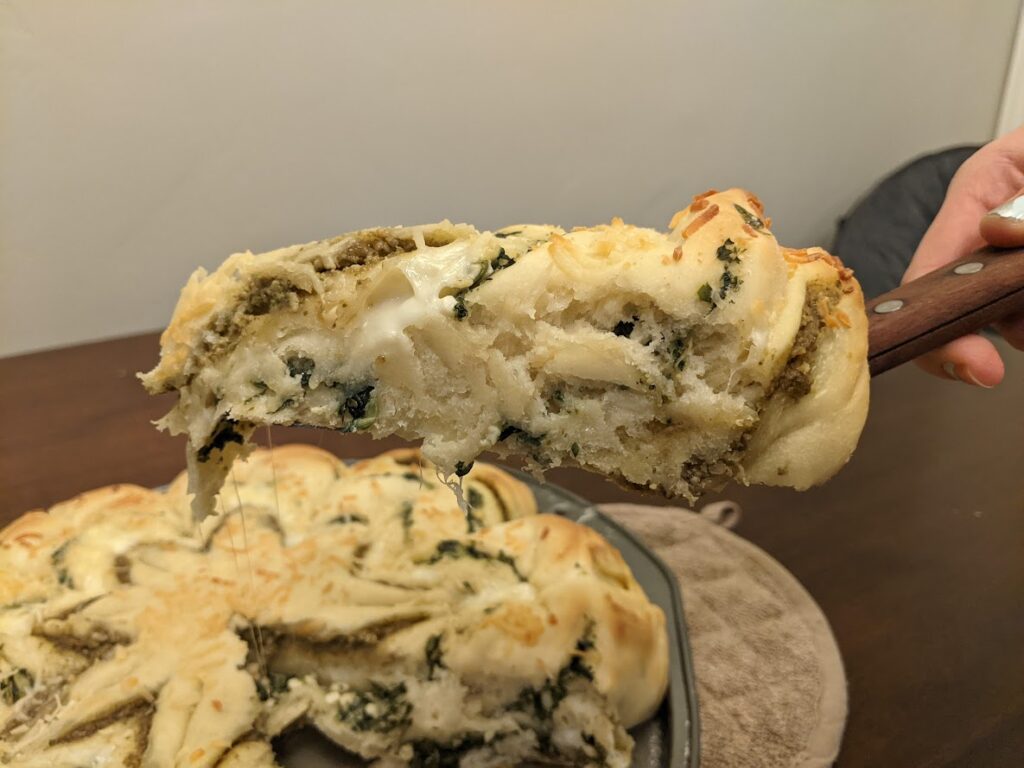 A slice of spinach pesto star bread.