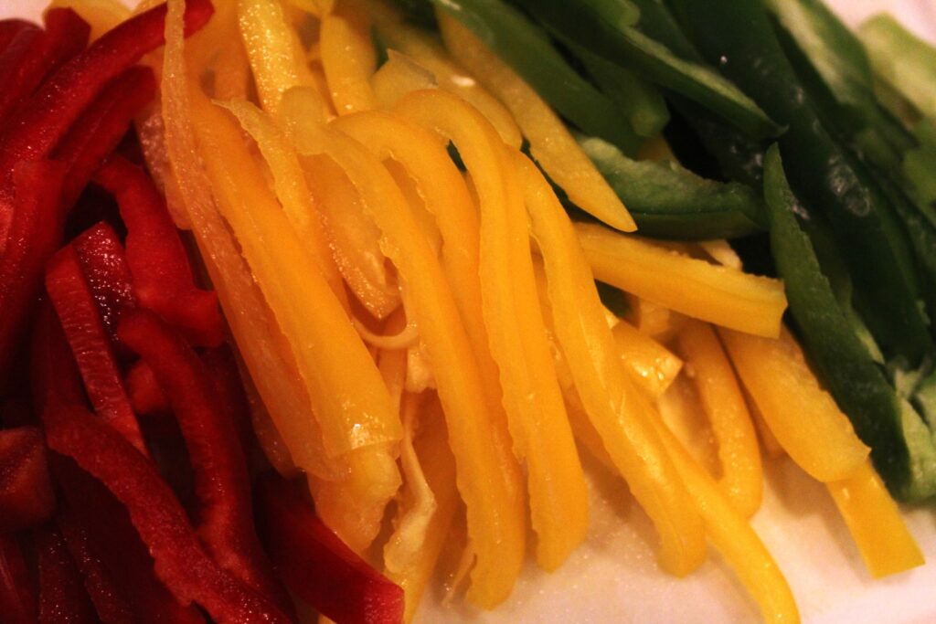 Sliced red yellow and green peppers.