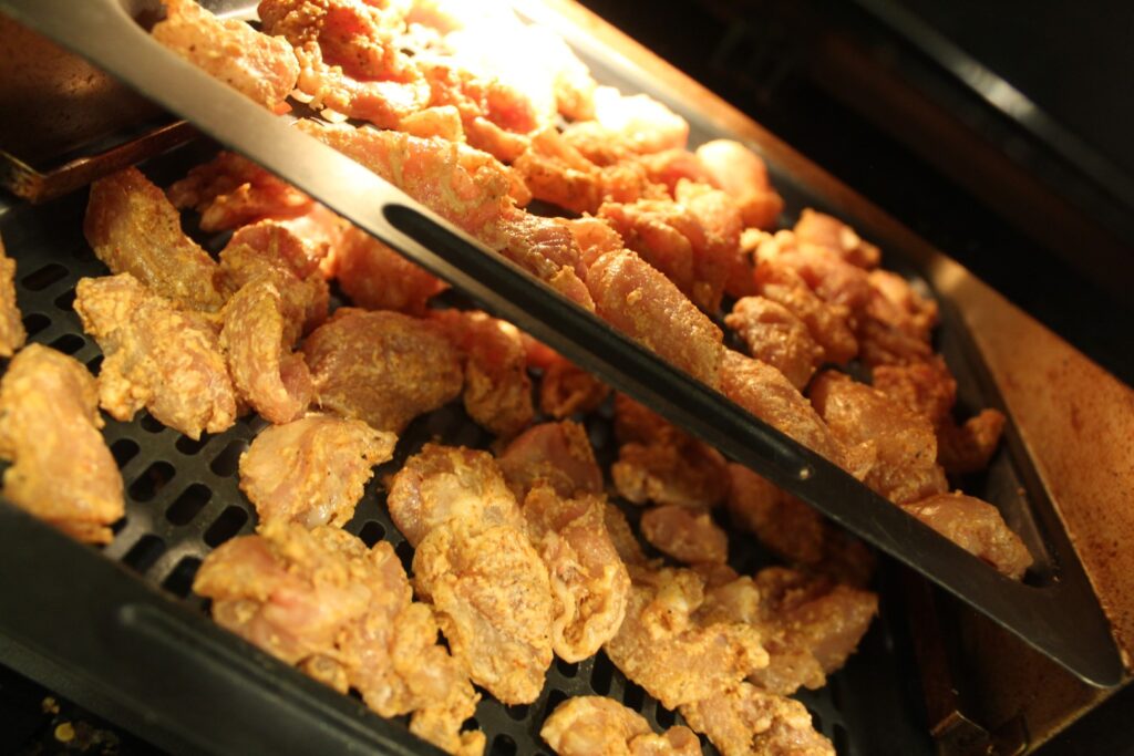 Raw breaded chicken in an air fryer.