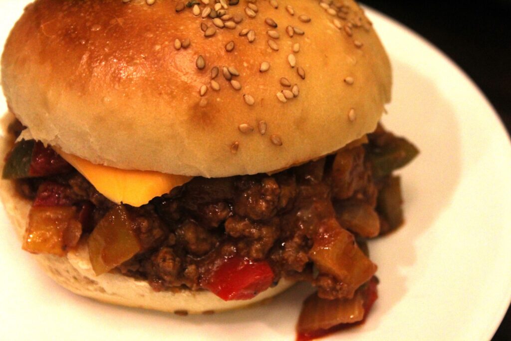 Veggie Balsamic sloppy joe filling with cheese on a homemade sesame seed bun.