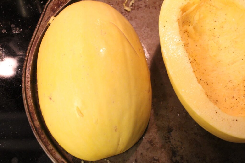 a seeded spaghetti squash salted and peppered.