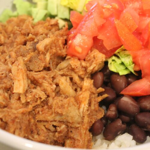 Rice bowl with Costa Vida sweet pork beans tomatoes and lettuce.