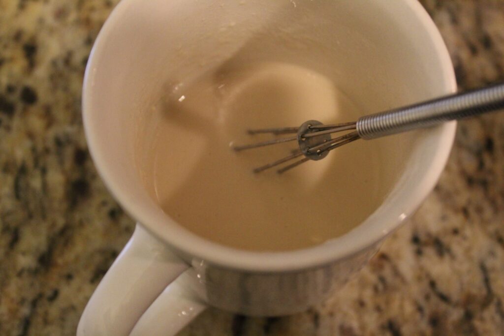 Flour whisked into broth in a mug