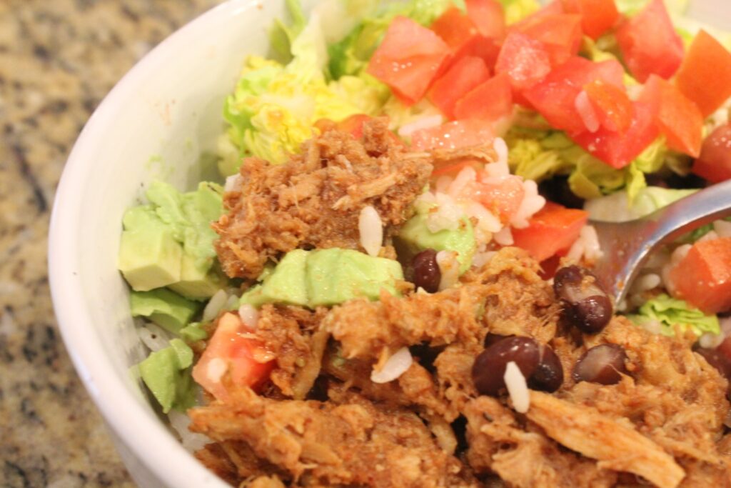 A fork of restaurant style sweet pork beans and vegetables.