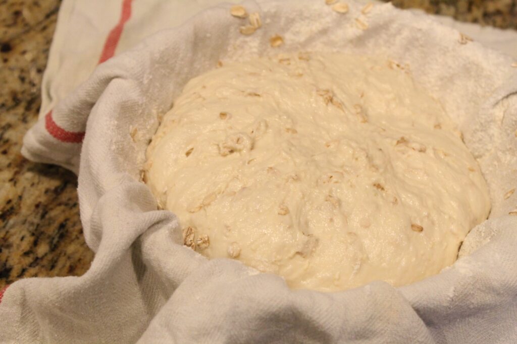 Sour dough honey oat bread shaped into a cloth covered bowl. 