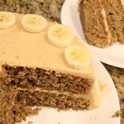 Sliced banana oat cake with peanut butter frosting topped with banana slices