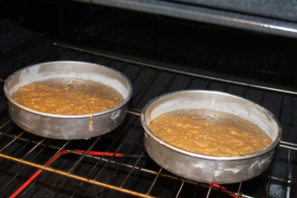 Cake pans with banana oat cake batter going into an oven.