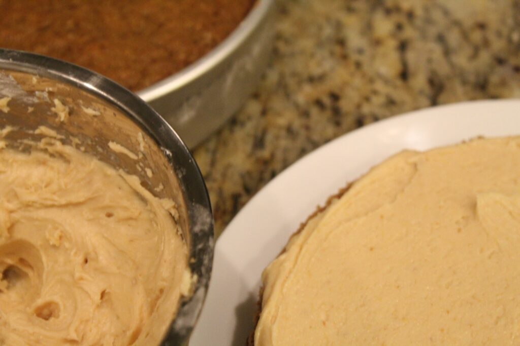 Frosting a cake with natural peanut butter frosting.