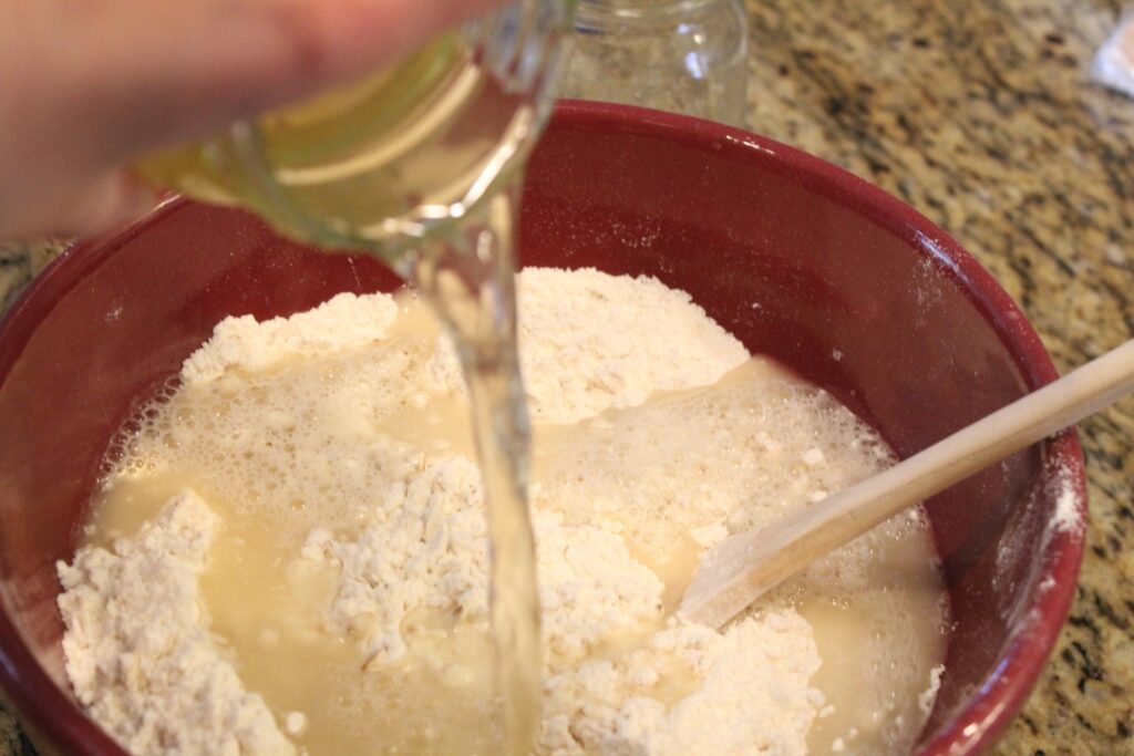 Pouring honey water into the oat and flour mixture.