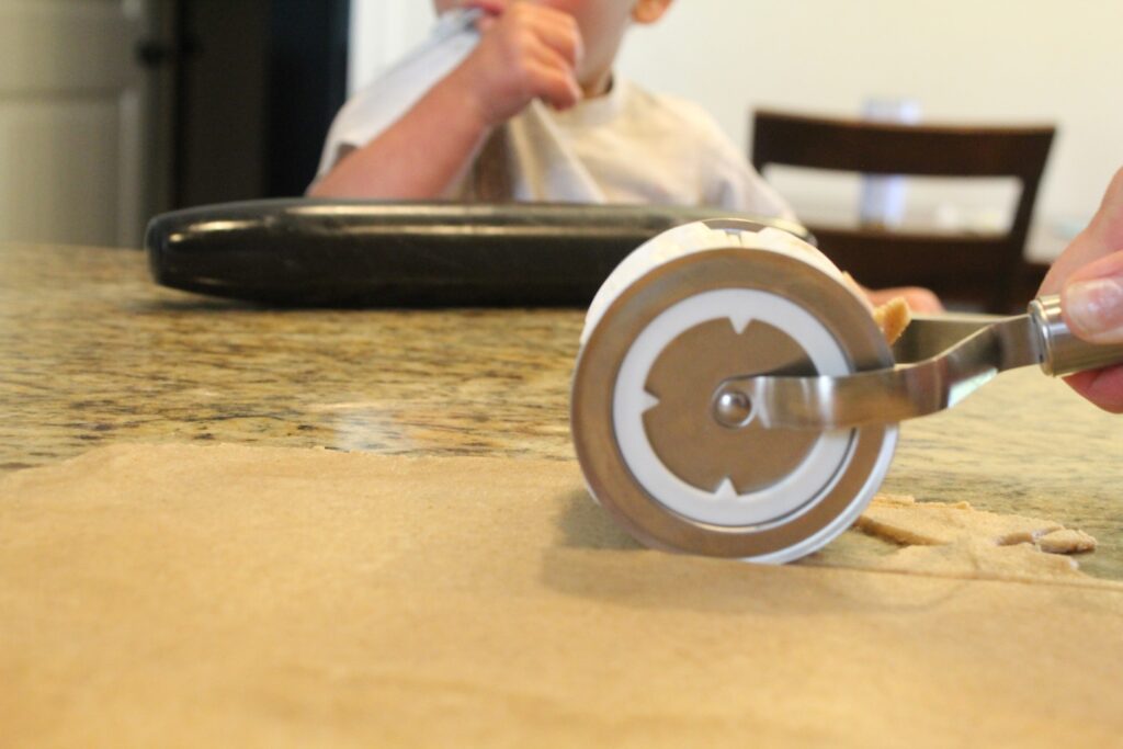 cutting animal shapes into sourdough graham cracker dough.