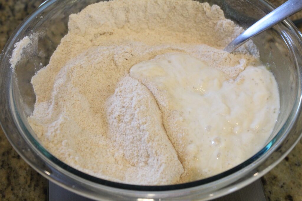 Added whole wheat flour and sourdough starter to a bowl.