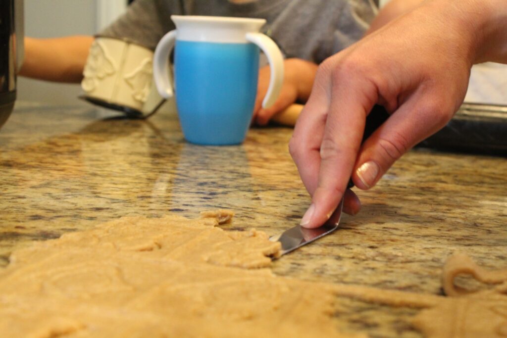 transferring sourdough animal graham cracker with a spatula.