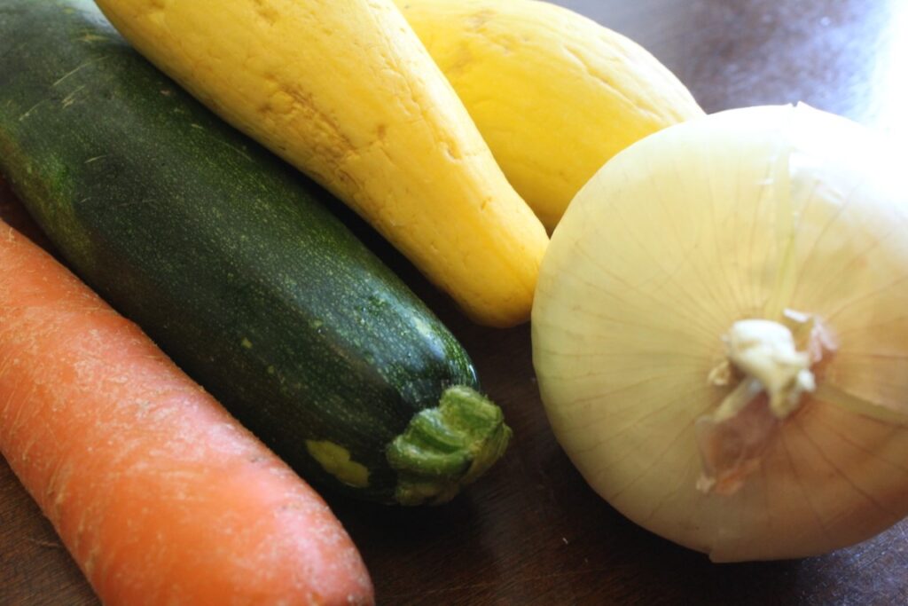 Zucchini, yellow squash, on onion and carrot. 