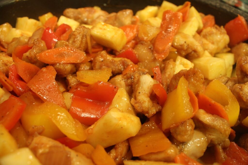 sweet and sour chicken with peppers carrots and pineapple.