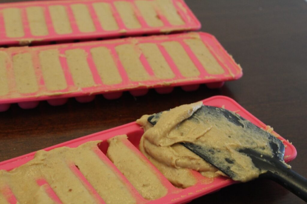 spreading peanut butter banana Popsicle batter into freezer molds.