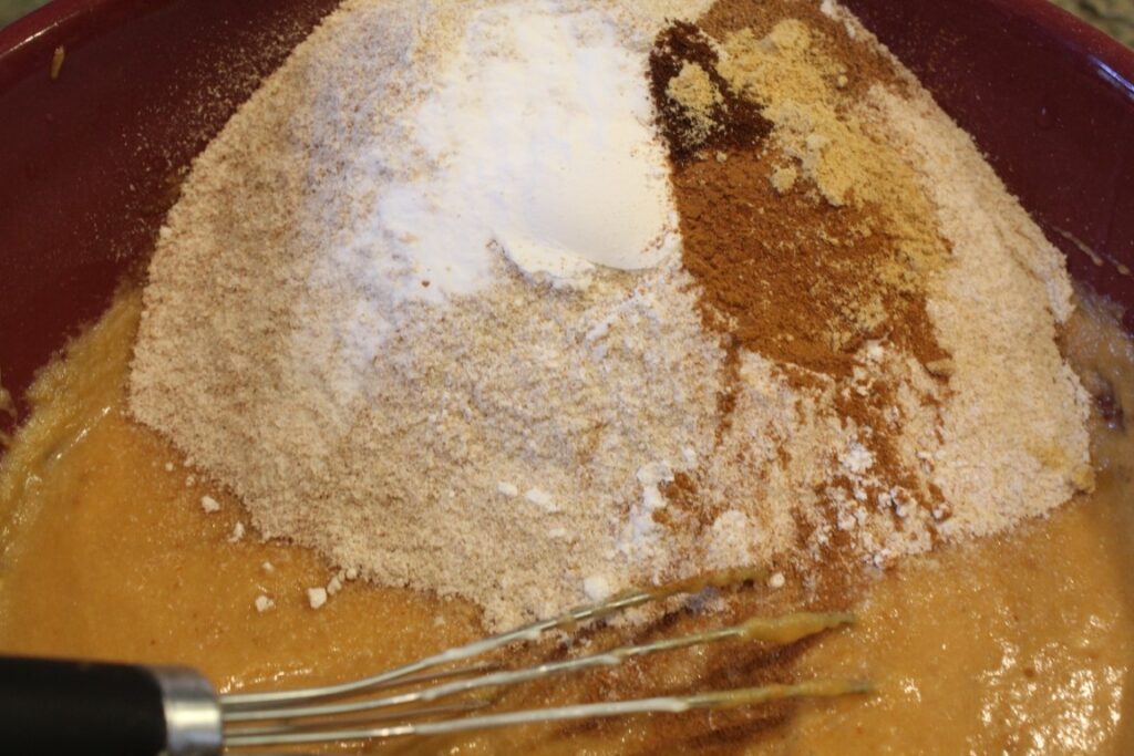 Adding dry ingredients for pumpkin applesauce doughnuts.