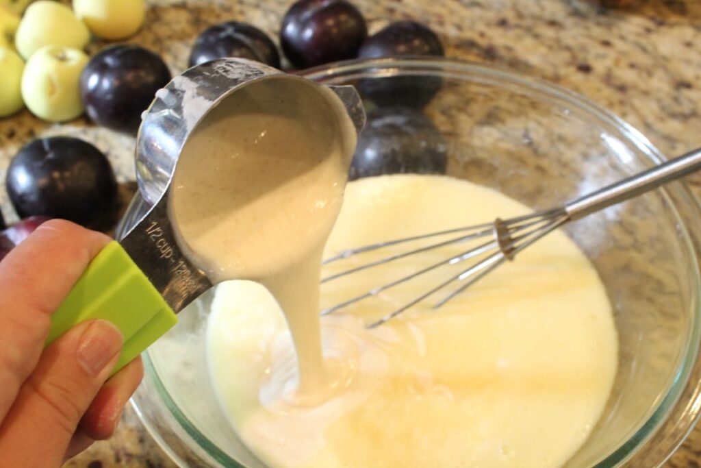 Pouring sourdough discard into a mixture of wet ingredients.