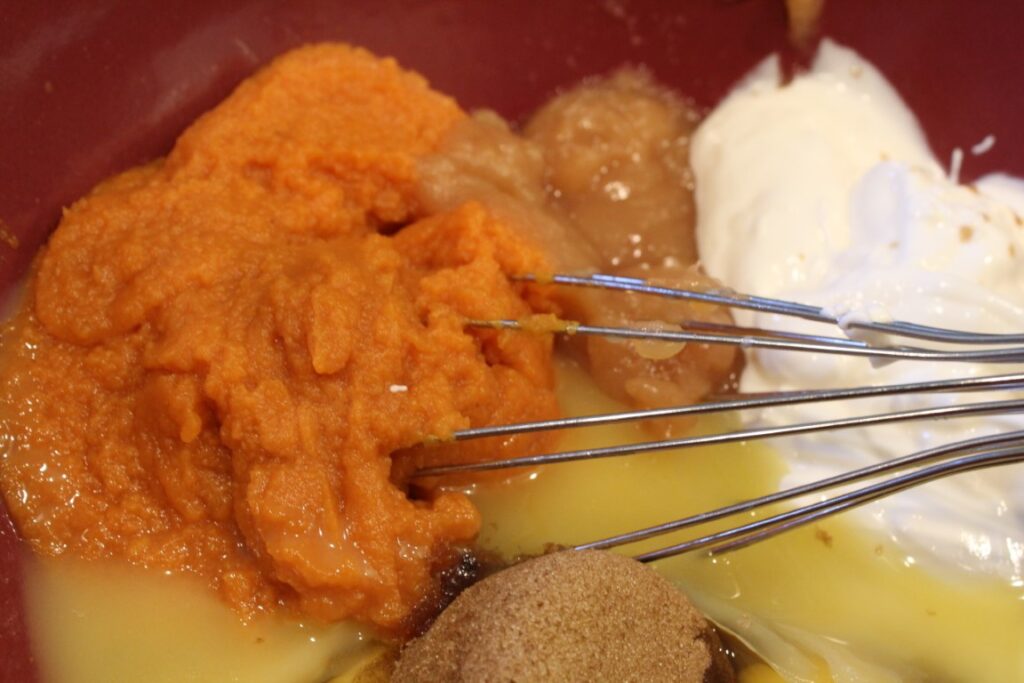 Mixing together wet ingredients for pumpkin applesauce doughnuts