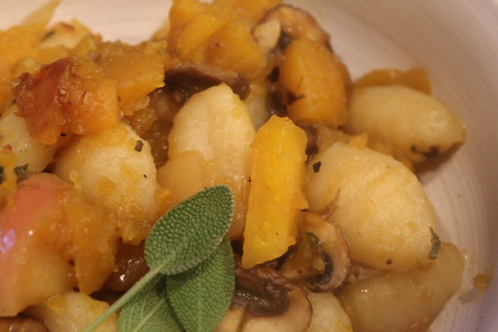 Dish of butternut squash gnocchi with apple and sage.