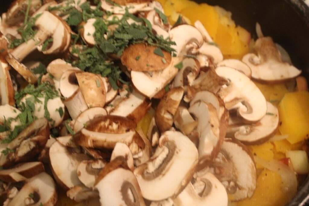 Adding sliced mushroom and sage to the pan. 