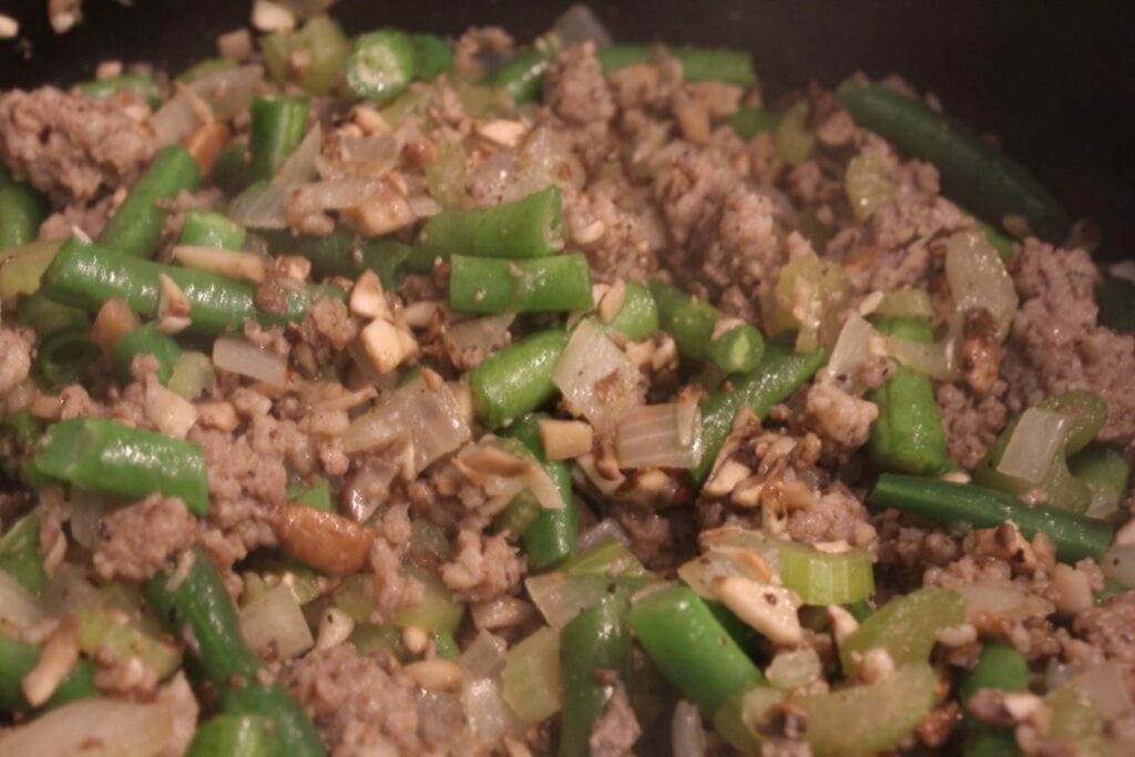 sauteing green bean and sausage mixture.