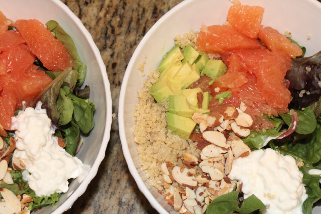 two bowls of Grape fruit salad with avocado, quinoa, almonds, and cottage cheese.