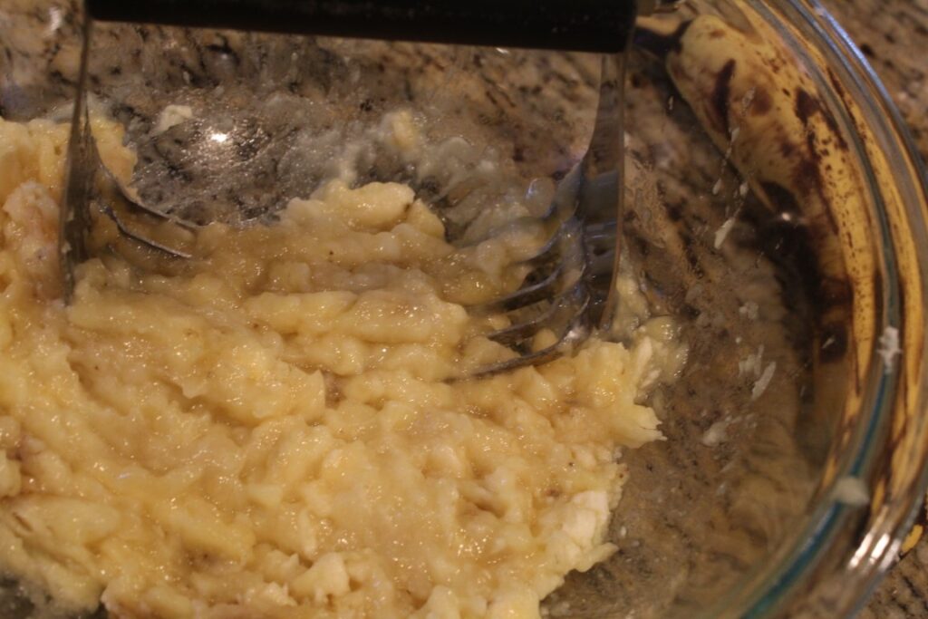 mashing bananas with a pastry cutter.