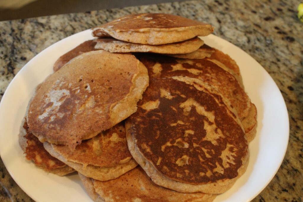 A pile of whole wheat banana pancakes on a plate.