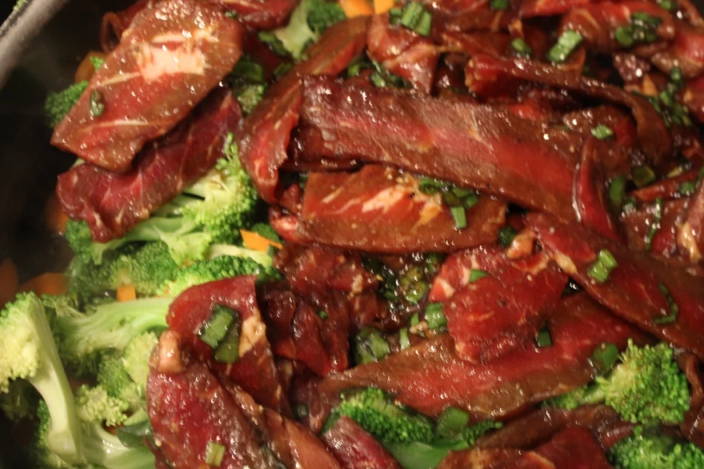 Marinated beef and vegetables in a frying pan.