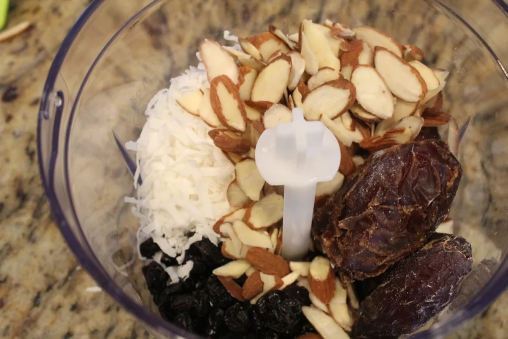 almonds, coconut flakes, raisins and dates in a food processor.