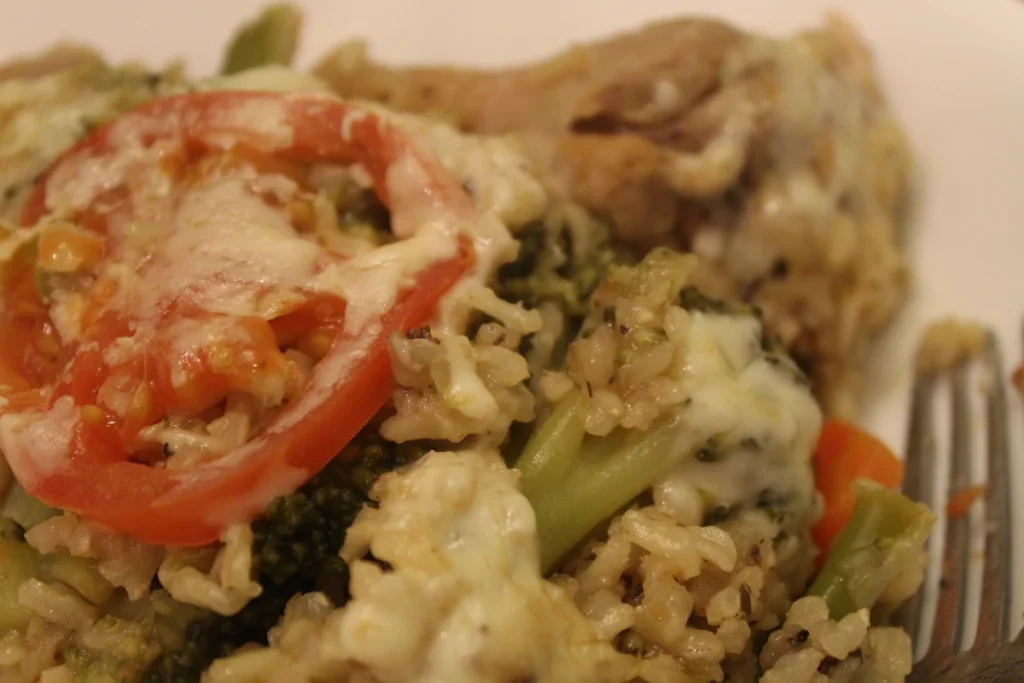 close up of a serving of one pot brown rice topped with tomato and cheese.