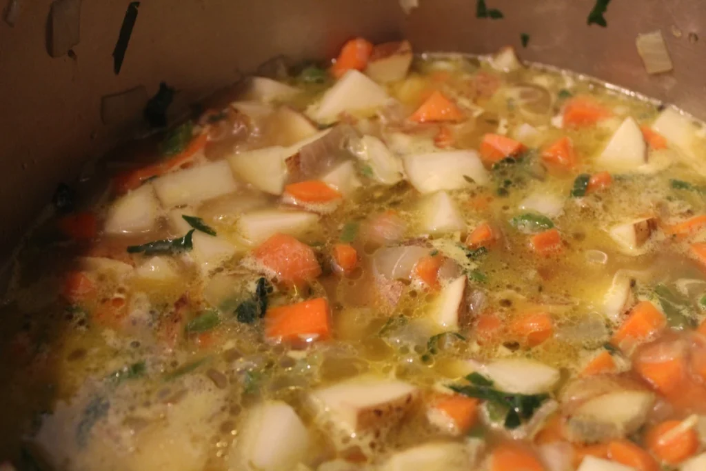 potatoes, carrots onions and celery simmering in chicken broth.