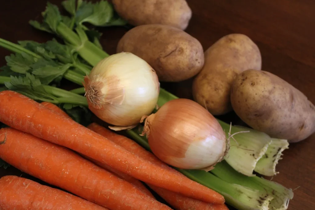 Stack of onions, potatoes, celery and carrots.