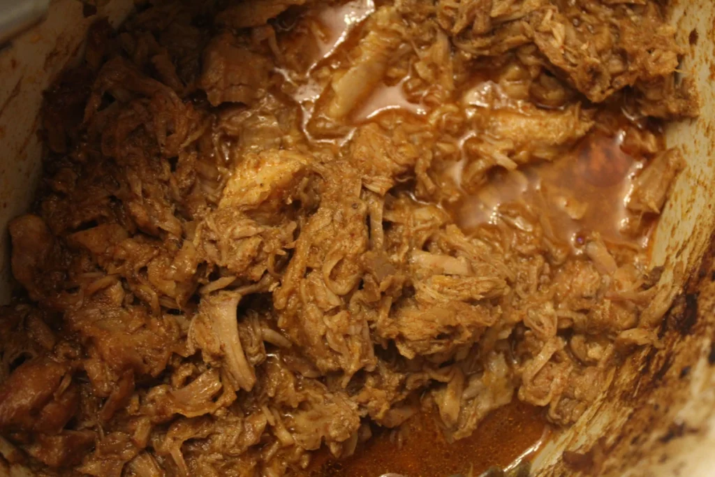 Shredded citrus pork in a slow cooker.