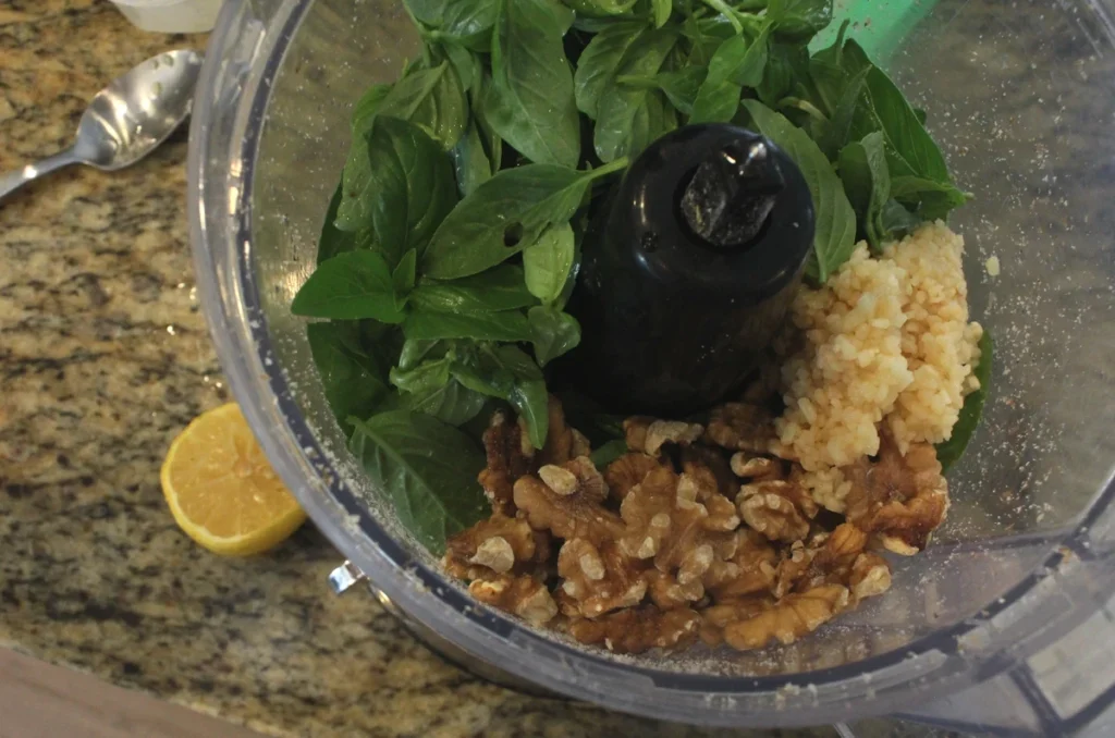 fresh basil, minced garlic, and walnuts in a food processor with half a lemon on the side.