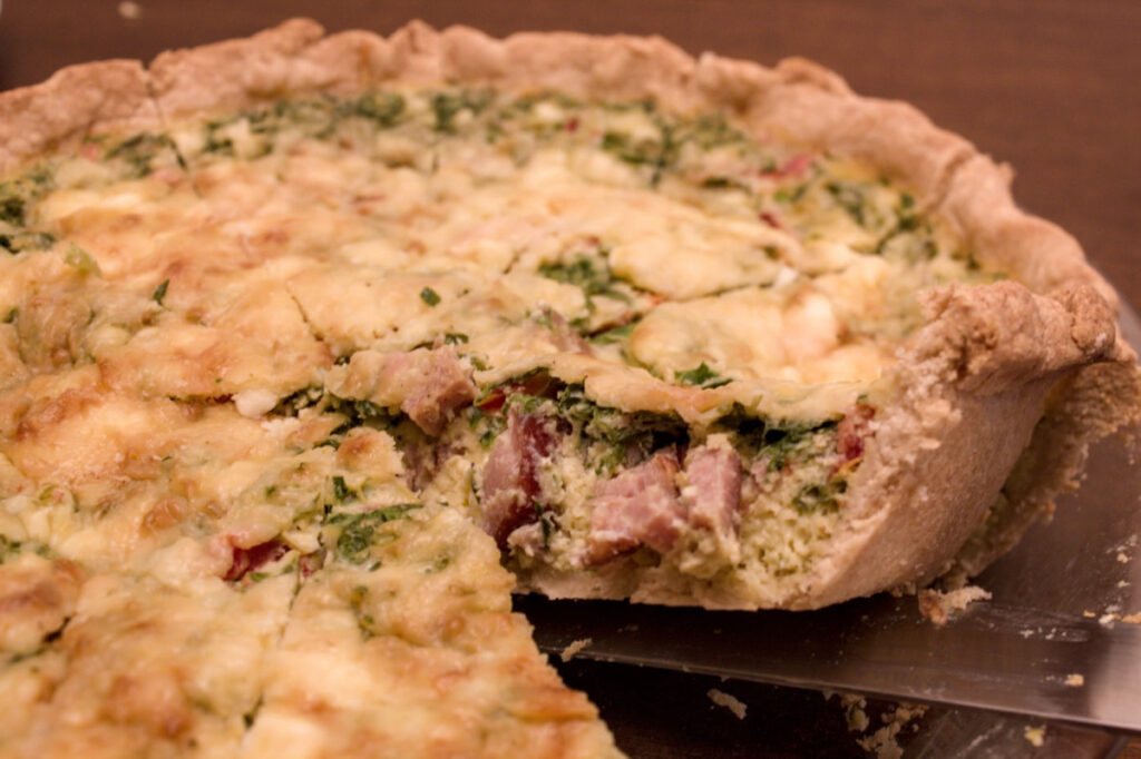 Sliced quiche with ham and greens.